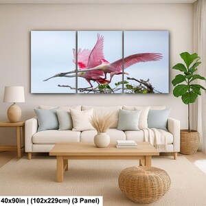 The image is a large, three-panel canvas print depicting a pink bird in flight, with a serene background of a tree branch and sky.