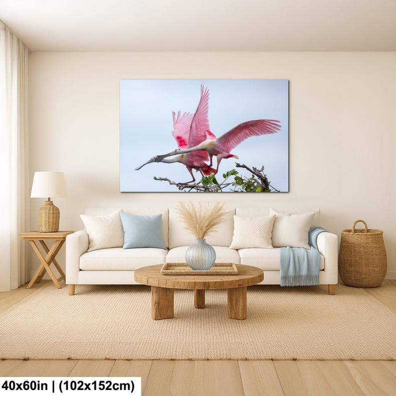 a large pink bird with outstretched wings perched on a branch, surrounded by greenery.