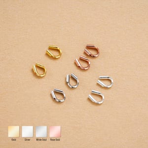 May include: An assortment of ear cuffs in gold, silver, white gold, and rose gold. The ear cuffs are U-shaped and appear to be made of metal. The image includes color swatches with labels for each metal type.