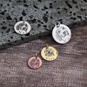 May include: Four silver and gold dog tag pendants with engraved images of dogs and names. The names are "Max", "Max", "Ares", and "Max".