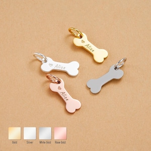 May include: Four bone-shaped pet tags in gold, silver, white gold, and rose gold. Each tag has a small heart and the name "Alice" engraved. The tags have a small ring for attachment to a collar.
