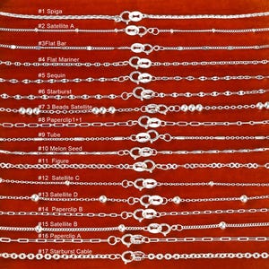 以下が含まれることがあります： 17個のシルバーネックレスのコレクション。それぞれユニークなチェーンデザインと留め金が付いています。 ネックレスは赤茶色の表面に表示され、「Spiga」や「Satellite A」など、各スタイルには番号と名前が付けられています。