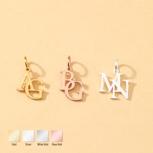 May include: Three initial pendant necklaces in gold, rose gold, and silver. The gold pendant displays the letters "AG", the rose gold pendant shows "BG", and the silver pendant shows "MN". The image also shows the color options: gold, silver, white gold, and rose gold.