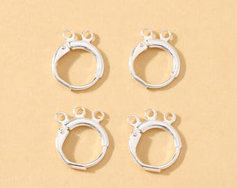 May include: Four silver-colored hoop earrings with a unique design. Each earring has a circular hoop with a hinged closure and three small loops at the top. The earrings are displayed against a light yellow background.
