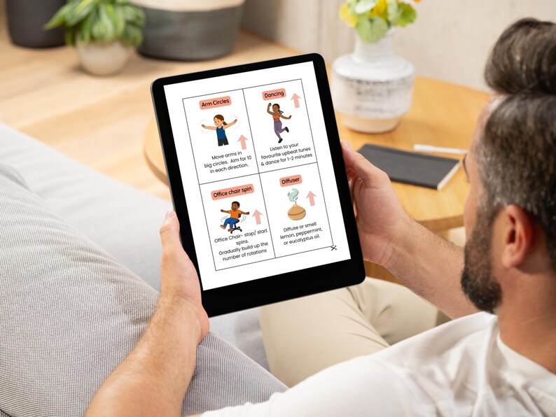 May include: A black tablet displays a wellness guide with illustrations and text. The guide includes instructions for arm circles, dancing, office chair spins, and using a diffuser. The tablet is held by a person sitting on a gray couch.