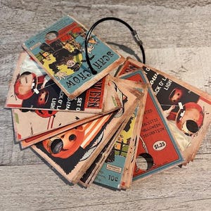 Könnte beinhalten: Ein Set vintage Halloween-Dekorationen mit einem Vogelscheuche, einem Kürbis und anderen gruseligen Figuren. Die Dekorationen sind auf Karton gedruckt und haben einen abgenutzten Look. Das Set enthält einen Ring zum Aufhängen. Der Text auf den Karten lautet "Scarecrow", "Jack O' Light", "10c", "$1.25" und "Realisitic Halloween Decoration".