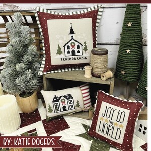 Puede incluir: Tres fundas de cojín de Navidad rojas y blancas con diseños de punto de cruz. La primera funda de cojín presenta una iglesia con el texto "Peace on Earth". La segunda funda de cojín presenta una casa con una corona. La tercera funda de cojín presenta el texto "Joy to the World".