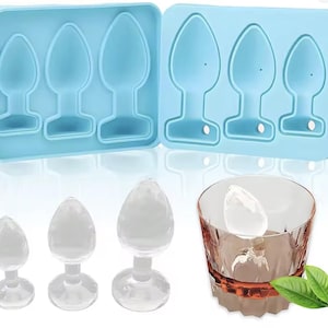 May include: A light blue silicone mold with three different sized shapes, and three clear glass objects of the same shape. A glass with a clear ice object and two green leaves are also in the image.