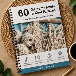 Könnte beinhalten: Ein Buch mit dem Titel "60 Makramee-Knoten & Knotenmuster" mit Spiralbindung. Das Cover ist blau und weiß, mit Text, der Schritt-für-Schritt-Anleitungen und die Eignung für alle Schwierigkeitsgrade angibt. Das Bild enthält Makramee-Materialien und eine Kaffeetasse.