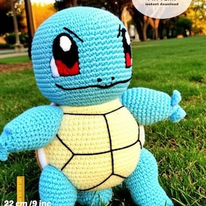 May include: A crocheted blue and yellow Squirtle plush toy, approximately 9 inches tall. The toy has black eyes, red cheeks, and a white mouth. The text "CROCHET PATTERN instant download" is in a white oval with an American flag.