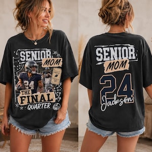 May include: A charcoal gray short-sleeve t-shirt featuring a football-themed graphic on the front with the text Senior Mom The Final Quarter and a player image. The back displays the text Senior Mom with the number 24 and the name Jackson.