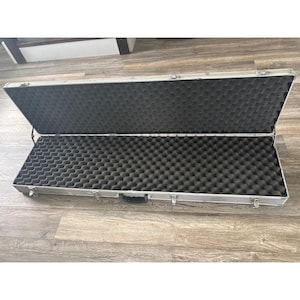 May include: An open, silver rectangular case with a black foam interior. The case has a handle and several latches. The interior foam is designed to protect the contents.