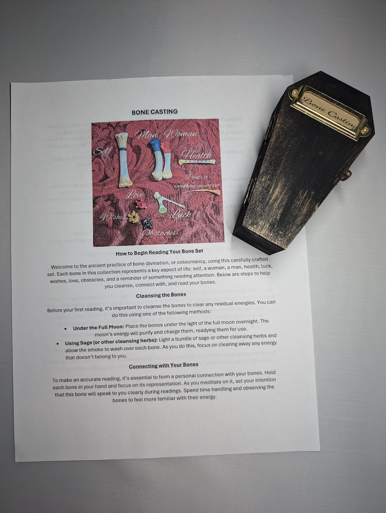 Op de afbeelding: Een zwarte, doodskistvormige doos met een gouden label met de tekst "Bone Casting" ligt naast een bedrukte pagina. De pagina bevat een diagram van botvormen en de woorden "Bone Casting" en instructies.