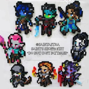 May include: Eight pixel art character designs featuring various fantasy characters. The characters are made of colorful beads and are arranged in a circle. The text "@SAINTASTRA SAINT'S SHOPPE ETSY *DO NOT COPY PATTERNS*" is in the center of the circle.