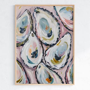 May include: An abstract painting of several oyster shells in shades of white, blue, and yellow against a pink background. The artwork is framed in a light wood frame, creating a coastal or nautical theme.