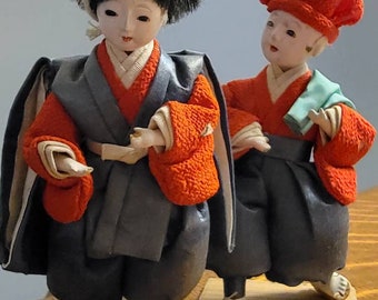 Pair of Vintage Asian Dolls in Silk - Gofun heads, visible tiny teeth, detailed costumes. One is a chef