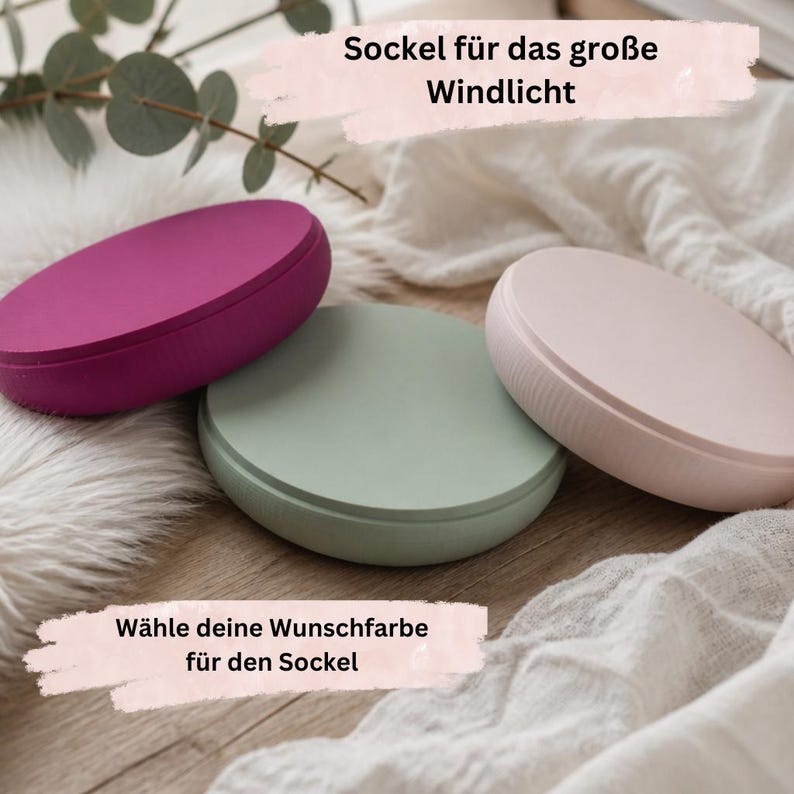 May include: Three circular, flat-topped bases for lanterns in magenta, sage green, and pale pink. The text on the image reads: Sockel f&uuml;r das gro&szlig;e Windlicht and W&auml;hle deine Wunschfarbe f&uuml;r den Sockel. Each base has a smooth, matte finish.