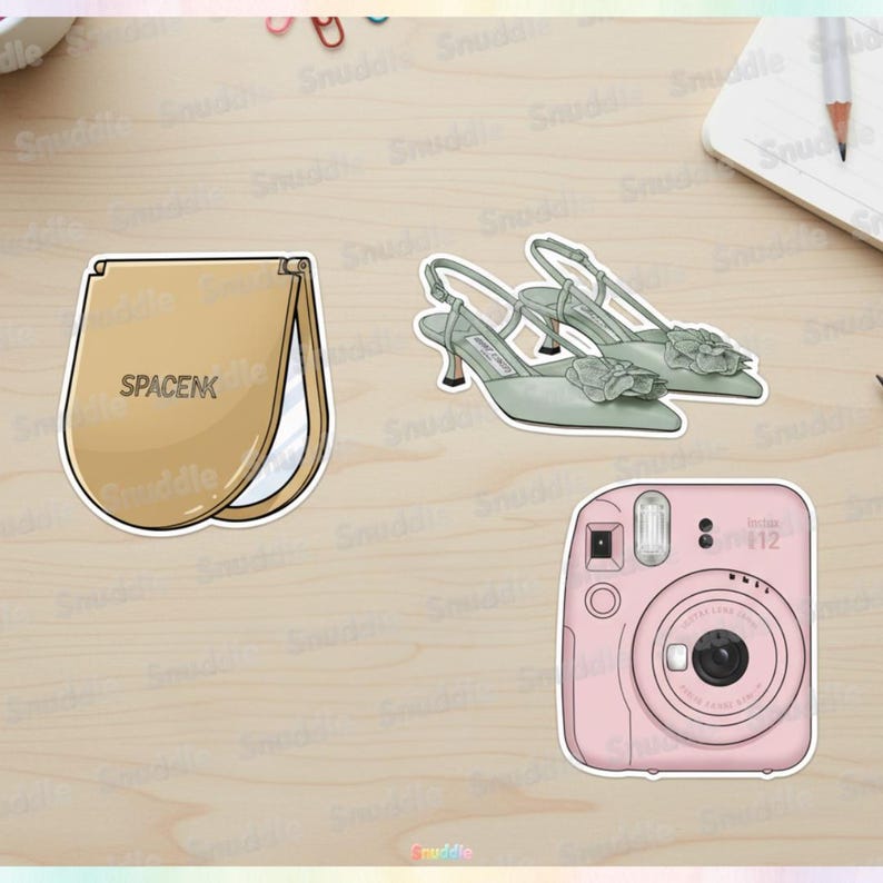 May include: A collection of stickers featuring a tan makeup mirror with the text "SPACENK", a pair of sage green heels with floral accents, and a pink Instax Mini 12 camera.