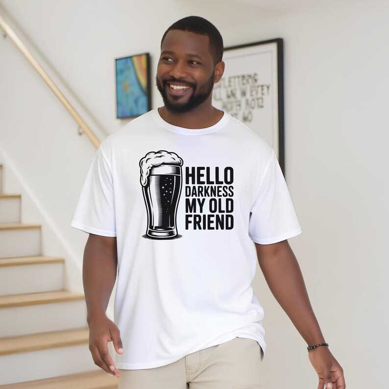 May include: White t-shirt with a black and white graphic of a beer glass and the text "Hello Darkness My Old Friend". The shirt is made of a lightweight material.