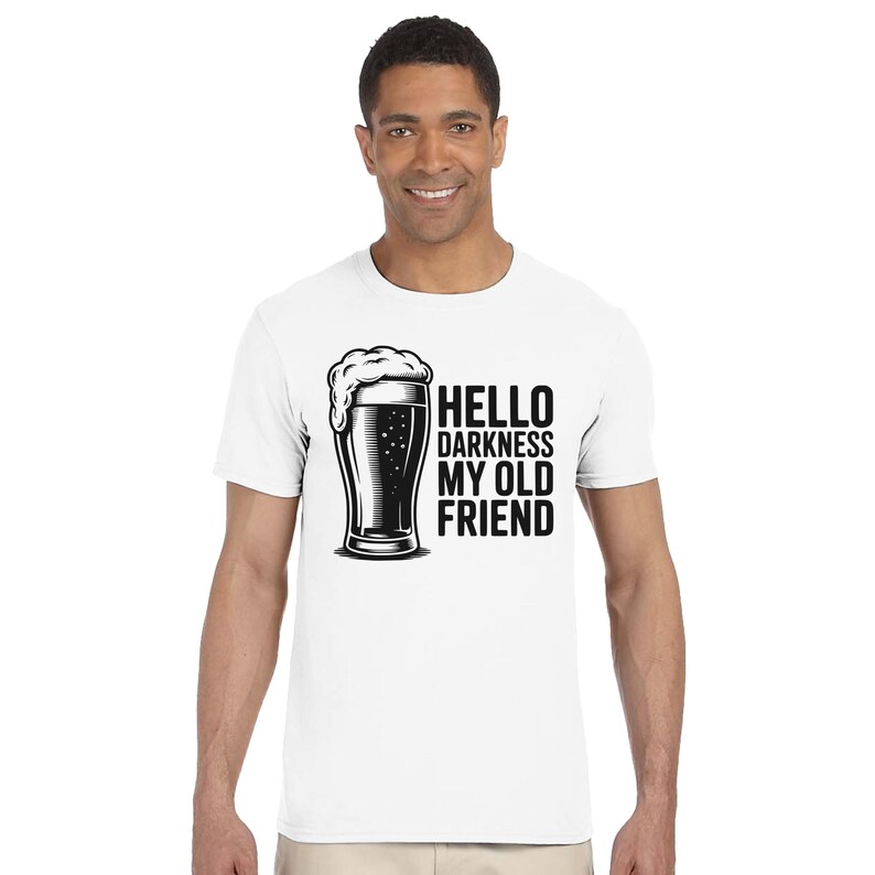 May include: White t-shirt with a black and white graphic of a beer glass and the text "HELLO DARKNESS MY OLD FRIEND". The shirt is a crew neck style.