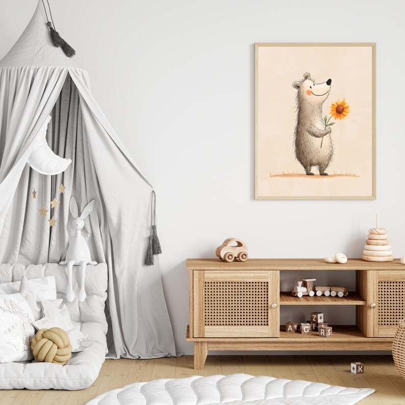 May include: A framed illustration of a smiling bear holding a sunflower. The artwork has a light beige background and is displayed in a child's bedroom. The room also features a gray canopy bed, a wooden cabinet, and decorative toys.