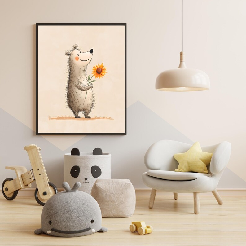 May include: A framed watercolor print of a smiling bear holding a sunflower. The artwork features soft colors and is displayed in a child's room with a wooden toy, a panda-themed storage bin, and a white chair with a yellow star pillow.