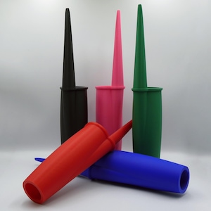 May include: A selection of bottle stoppers in black, pink, green, red, and blue. Each stopper has a cylindrical base and a long, tapered top. The red and blue stoppers are lying down.