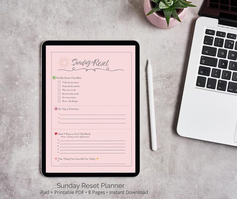 May include: A pink digital planner with the text "Sunday Reset" in a black script font. The planner includes a weekly reset checklist, top priorities, how I want to feel this week, and one thing I'm grateful for today. The planner is displayed on a tablet with a white stylus next to it.