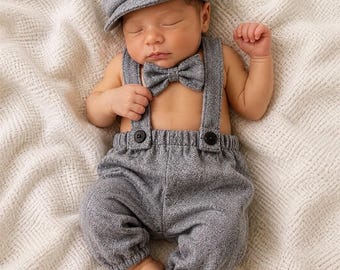 Set di accessori per foto di neonato: pantaloni con bretelle grigi, papillon e cappello da strillone.