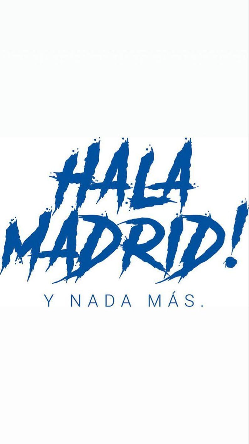 May include: White background with the words "HALA MADRID!" in blue, stylized, brushstroke font. Below, in smaller blue text, it reads "Y NADA M&Aacute;S."