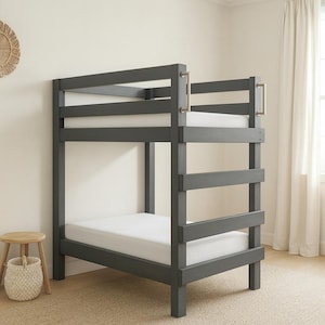May include: A gray wooden bunk bed with white mattresses. The bed has a ladder and safety rails. The room has a neutral color palette with a small wooden stool and a woven basket.