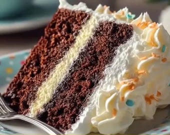 May include: A slice of chocolate cake with a cream filling and white frosting, decorated with orange and blue sprinkles. The cake sits on a plate with a fork.