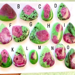 Peut inclure: Collection de pierres précieuses de rubis zoïsite polies. Les pierres présentent un mélange de rouge foncé, de rose et de vert. Chaque pierre a un motif et une répartition des couleurs uniques, idéale pour la joaillerie ou la collection.
