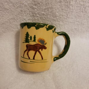 May include: A set of three ceramic mugs with a speckled, matte finish. The mugs are in shades of cream, light gray, and dark gray. Each mug has a simple, minimalist design, perfect for coffee or tea.