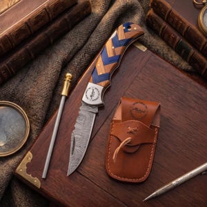 May include: A folding knife with a patterned wooden handle and a Damascus steel blade rests on a wooden surface, next to a leather sheath. A magnifying glass, pen, and vintage books complete the scene, suggesting a theme of exploration or craftsmanship.
