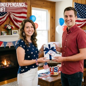 May include: A couple holding a gift box with a blue ribbon, celebrating Independence Day. The box has a tag that says "Happy Independence Day". The background includes American flags, balloons, and a fireplace. Text at the top says "BEST INDEPENDANCE DAY GIFT".