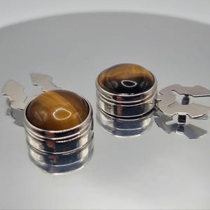 Gemelos con botón de ojo de tigre: botones a presión en tono plateado