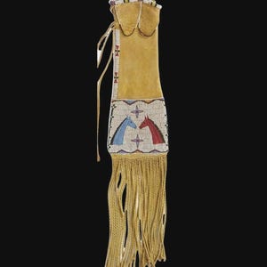 Puede incluir: Una bolsa de cuero color canela con un diseño de cuentas que presenta dos caballos, uno azul y otro rojo. La bolsa tiene flecos en la parte inferior y un cierre de cordón. La parte superior está decorada con pequeñas cuentas.