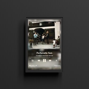 K&ouml;nnte beinhalten: Ein gerahmtes digitales Kunstwerk zeigt eine Vintage-Fotografie einer Gruppe von Menschen. Das Kunstwerk zeigt eine Musikplayer-Oberfl&auml;che mit dem Songtitel "Fortunate Son" von Creedence Clearwater Revival. Der Rahmen ist schwarz.