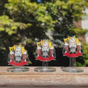 Peut inclure: Trois &eacute;pingles en m&eacute;tal argent&eacute; repr&eacute;sentant un personnage de dessin anim&eacute; tenant deux mugs de bi&egrave;re. Le personnage a les cheveux blancs et une barbe. Les &eacute;pingles sont sur des supports en plastique transparent. Les &eacute;pingles ont un fond jaune en forme d'&eacute;toile et une banni&egrave;re rouge avec le texte "10 Years".