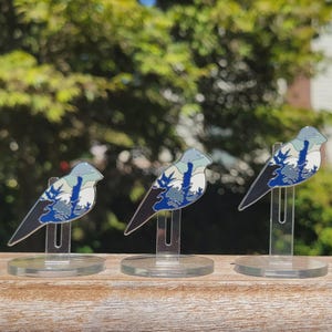 Peut inclure: Trois &eacute;pingles argent&eacute;es avec un motif de paysage de montagne bleu, blanc et gris. Chaque &eacute;pingle est sur un support en plastique transparent.