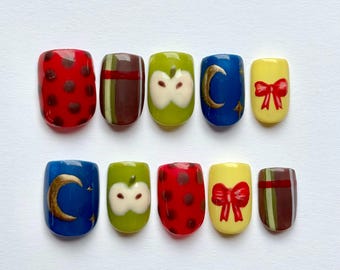 Unghie finte con frutta stravagante per l'autunno: motivo a pois color mela, fiocco rosso, scozzese, luna e stelle dorate, vestibilità personalizzata