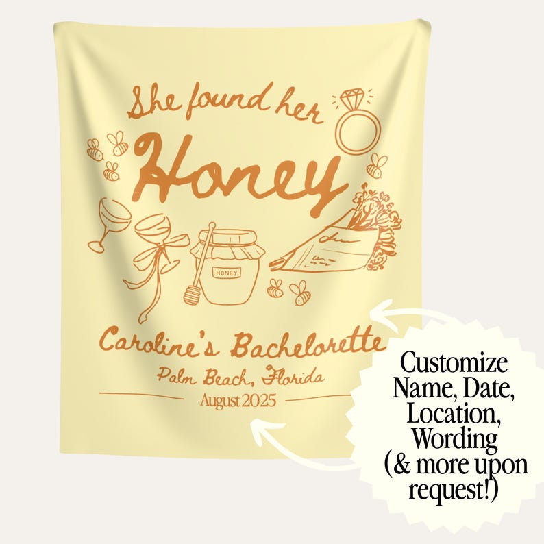 May include: A light yellow tapestry with orange text and illustrations. The text reads "She found her Honey" and "Caroline's Bachelorette" with the location and date. Illustrations include a ring, bees, wine glasses, and a jar of honey.