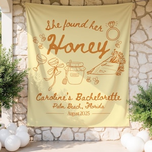 May include: A light yellow banner with brown text and illustrations. The banner reads "She found her Honey" with images of a ring, bees, wine glasses, a jar of honey, and flowers. The text "Caroline's Bachelorette, Palm Beach, Florida, August 2025" is also included.