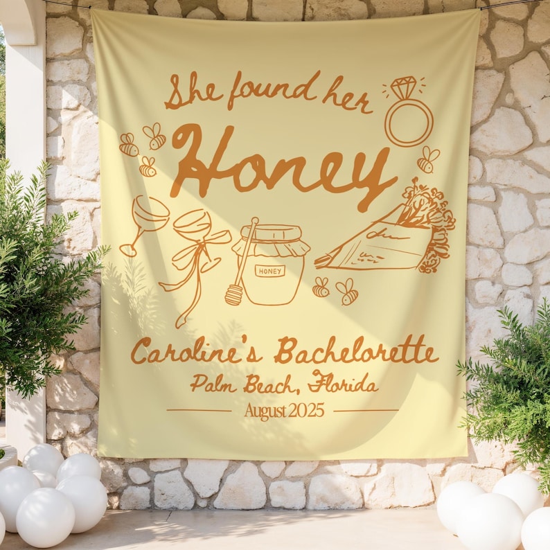 May include: A light yellow banner with brown text and illustrations. The banner reads "She found her Honey" with images of a ring, bees, wine glasses, a jar of honey, and flowers. The text "Caroline's Bachelorette, Palm Beach, Florida, August 2025" is also included.