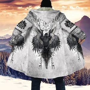 May include: A white hooded cloak featuring a large black raven with outstretched wings on the back. The cloak has intricate Viking-inspired designs and symbols, with a faux fur lining and a mountain landscape background.