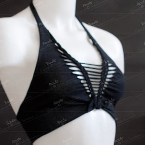May include: A black halter top with a criss-cross design and cutouts. The top is made of a soft, stretchy fabric.