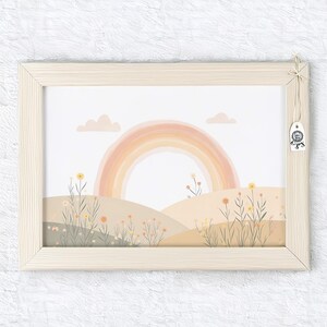 May include: A framed art print featuring a pastel rainbow over rolling hills with wildflowers. The artwork is in a light wood frame and includes a small tag. The color palette is soft and inviting, perfect for a nursery or children's room.