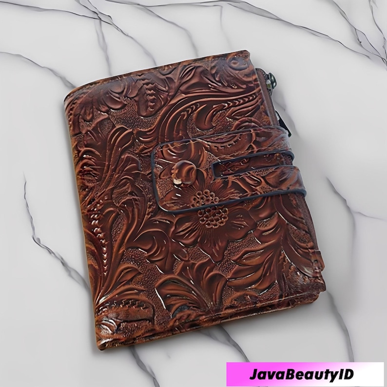May include: A brown leather wallet with a floral embossed design. The wallet has a snap closure and a zipper. The overall design is detailed and textured, with a rich, warm colour.
