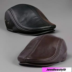 Puede incluir: Dos gorras planas de cuero, una negra y otra marrón, se muestran sobre un fondo gris. Las gorras tienen un diseño clásico con una corona redondeada y una visera pequeña y rígida. Las gorras están hechas de cuero liso y brillante.
